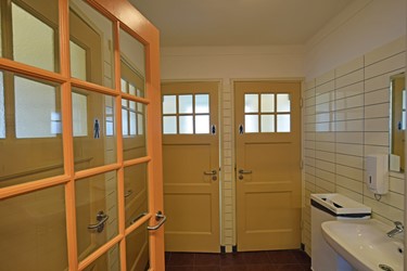 <p>Een deel van de indeling van de toiletten dateert nog uit de bouwtijd. In dit deel bleven ook de oorspronkelijke deuren en de plafondafwerking bewaard. </p>
